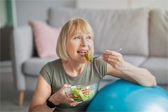 woman eating salad in her home