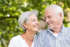 older couple smiling while looking at each other 