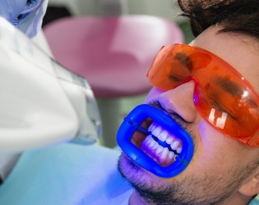 Man getting professional teeth whitening in dental office