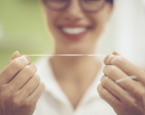 Person holding string of dental floss