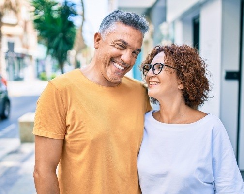 Man and woman hugging on city sidewalk