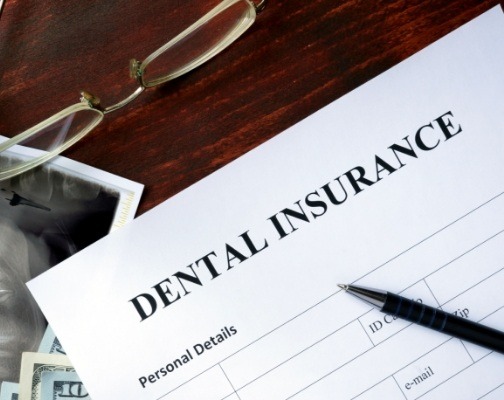 Dental insurance form on dark wood table