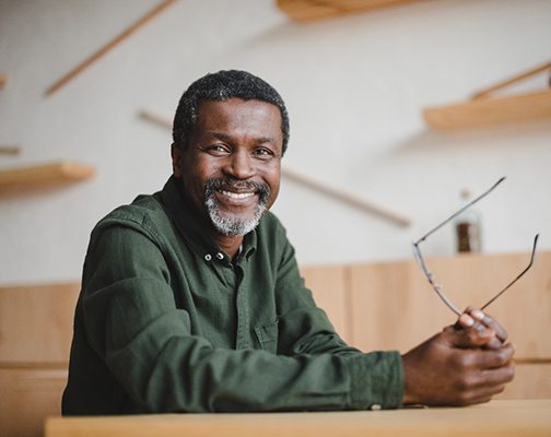 man smiling while holding glasses