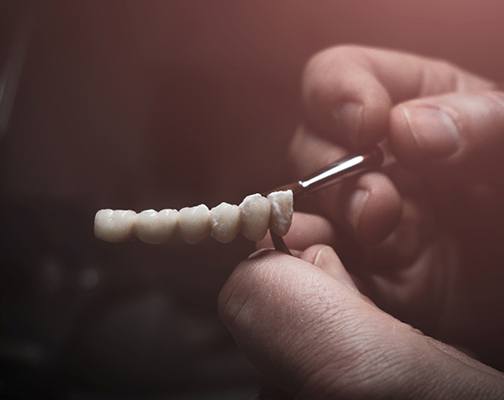 Lab technician painting replacement teeth