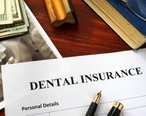 Dental insurance form on dark wood table