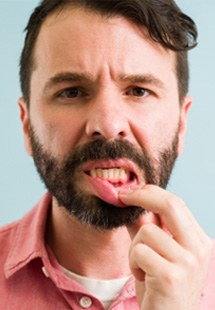 man pointing to inflamed gums 