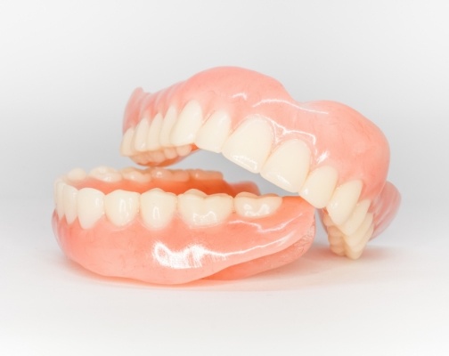 Two full dentures resting on flat surface