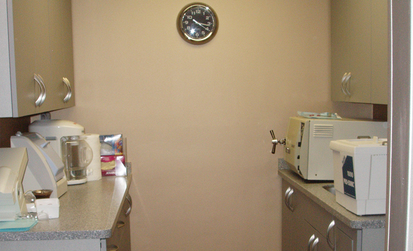 Analog clock on dark yellow wall of dental office