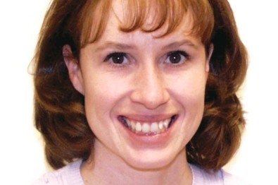 Woman with curly brown hair smiling