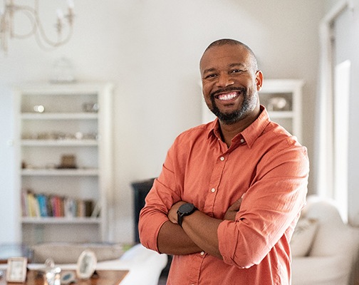 Man standing and smiling with his arms folded