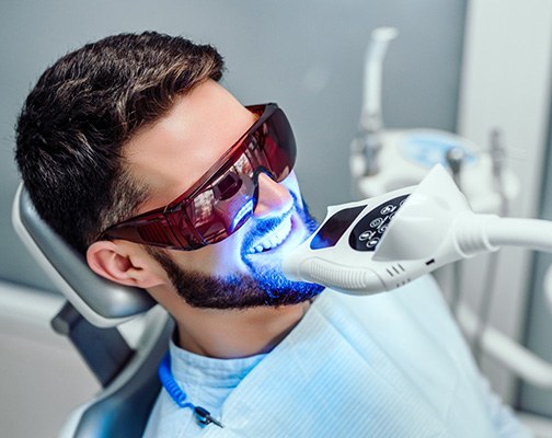 A closeup of a man receiving teeth whitening treatment