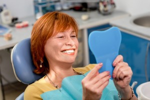 smiling woman happy with the dental implants brookline residents prefer