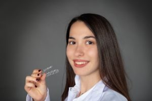 woman holding invisalign