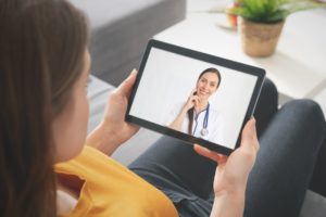 Woman videochatting her dentist while sitting