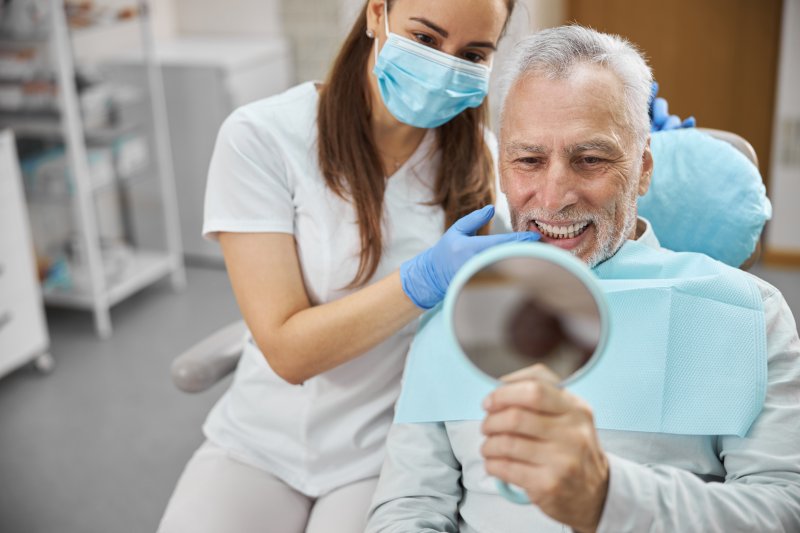 A senior man happy with his new dental implants
