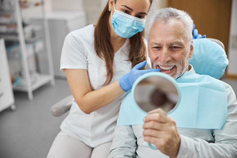 A senior man happy with his new dental implants