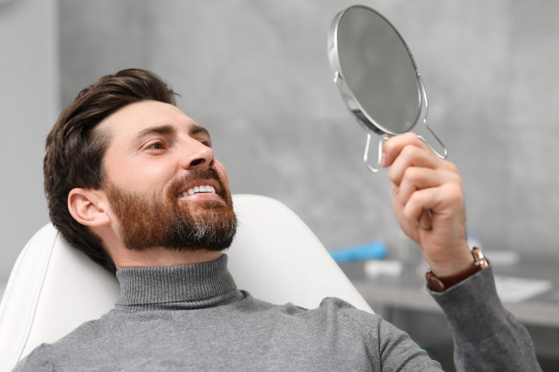 Patient smiling after teeth whitening with dental implants