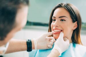 a cosmetic dentist examining a patient's teeth