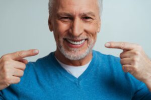 Man smiling after his dentist helped fix his denture sores