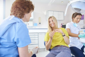 Woman in dental chair holding Invisalign tray