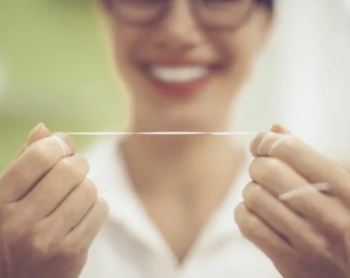 Person holding string of dental floss