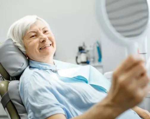 Senior woman smiling in dental chair at Boston Smile Center